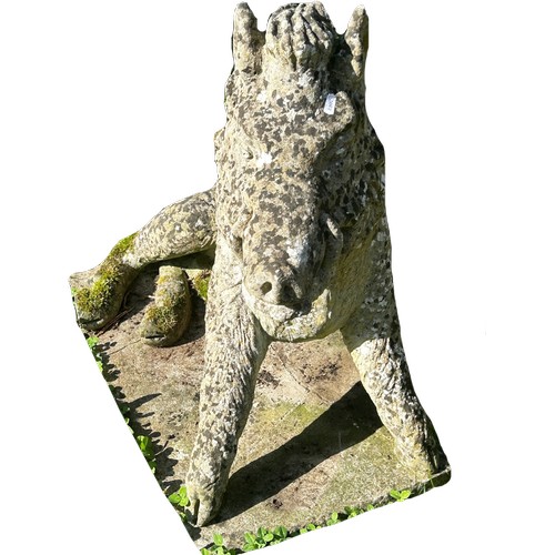 1064 - A well weathered cast composition stone garden ornament/study of a life size seated wild boar set on... 