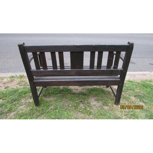 1001 - A stained and weathered teak two seat garden bench with slatted seat and back, 118 cm wide