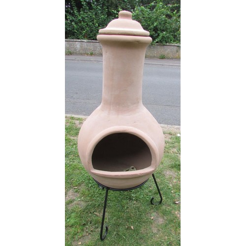 1010 - A clay chimenea raised on a simple iron work stand (appears hardly if ever used) 122 cm high