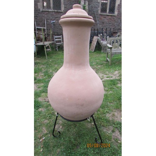 1010 - A clay chimenea raised on a simple iron work stand (appears hardly if ever used) 122 cm high