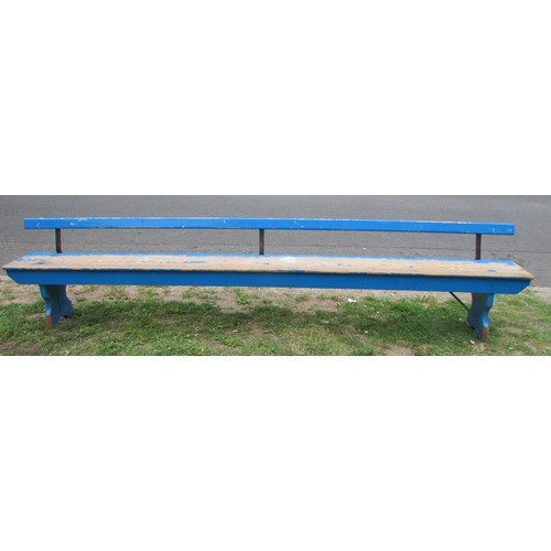 1057 - An old blue painted and partially stripped pine railway bench with simple rail back over a plank sea... 