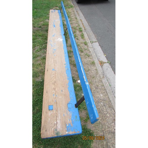 1057 - An old blue painted and partially stripped pine railway bench with simple rail back over a plank sea... 