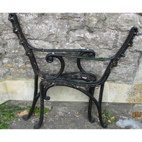 1030 - A pair of cast iron garden bench ends with scrolled arms and supports