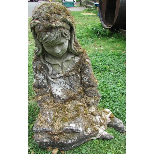 1019 - A well weathered moss encrusted garden ornament in the form of  a girl/young woman in seated pose re... 