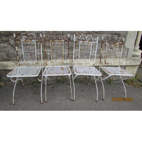 1002 - A set of four painted and weathered white metal folding terrace chairs with open scrollwork detail (... 