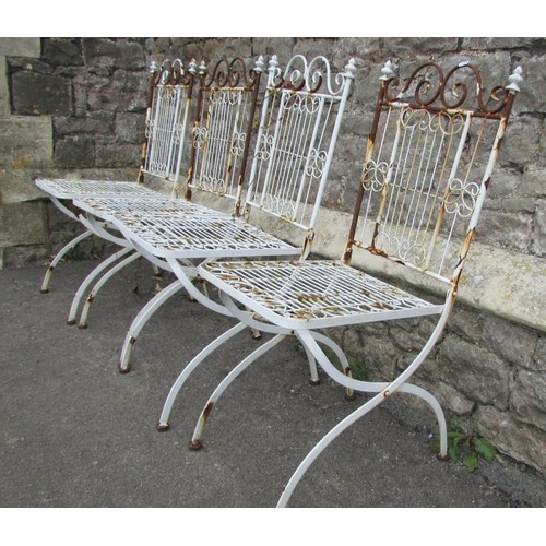 1002 - A set of four painted and weathered white metal folding terrace chairs with open scrollwork detail (... 