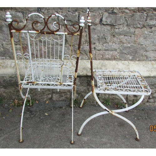 1002 - A set of four painted and weathered white metal folding terrace chairs with open scrollwork detail (... 