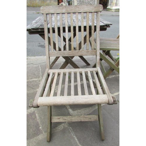 1043 - A weathered teak garden terrace table with slatted top, 70 cm square raised on folding x framed supp... 