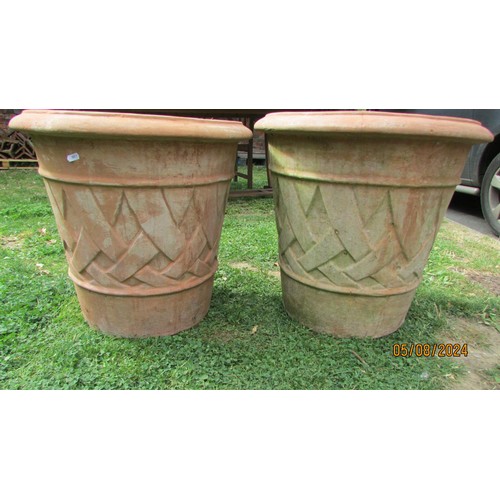 1075 - A pair of terracotta planters of circular tapered form with lattice detail, 58 cm diameter x 54 cm h... 