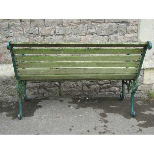 1078 - A two seat garden bench with weathered wooden slatted seat and combined back raised on decorative pa... 