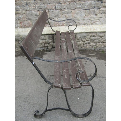 1071 - A vintage garden bench with stained wooden slatted seat and simple rail back raised on sprung steel ... 