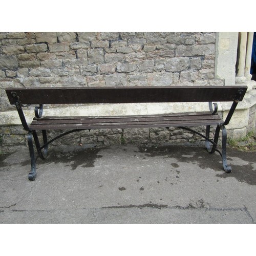 1071 - A vintage garden bench with stained wooden slatted seat and simple rail back raised on sprung steel ... 