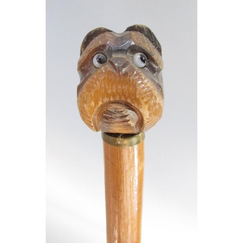 424 - Three walking sticks carved wood dog head handle, a Greyhound, a Bulldog and a Schnauzer.