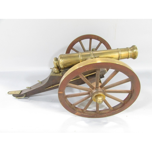 447 - A model brass field canon on a wooden carriage 43cm x 26cm approximately and a ship’s canon, 26cm x ... 