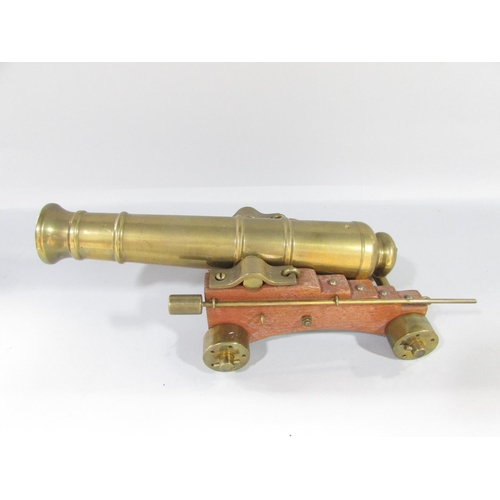 447 - A model brass field canon on a wooden carriage 43cm x 26cm approximately and a ship’s canon, 26cm x ... 