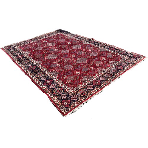 1753 - A Tabriz carpet with a repeating floral geometric pattern in tones of red and blue 330cm x 250cm app... 