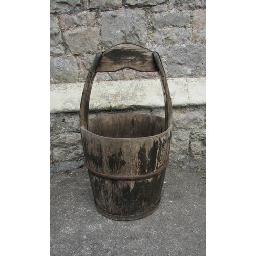 1119 - An old weathered coopered well bucket with ironwork strap mounts and integral handle, 67cm high, 33c... 