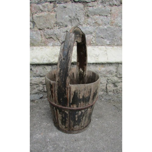 1119 - An old weathered coopered well bucket with ironwork strap mounts and integral handle, 67cm high, 33c... 