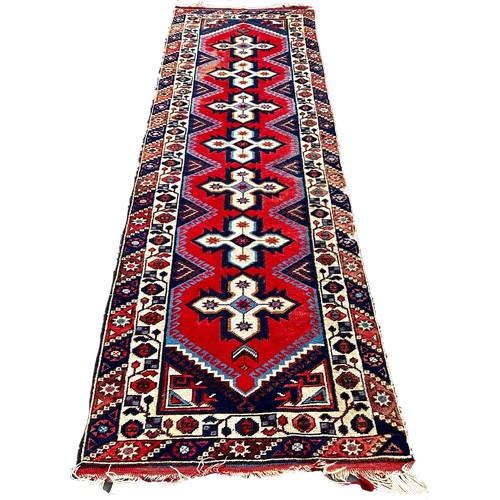 1761 - A Kazak type runner with seven star medallions on a red ground, 300cm x 80 cm