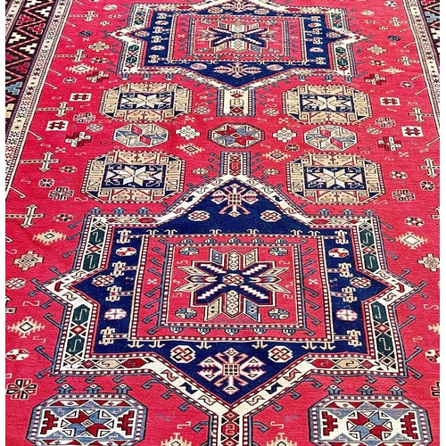 1766 - A Middle Eastern flat weave carpet with two lozenge shaped medallions on a pink ground, 275cm x 190c... 