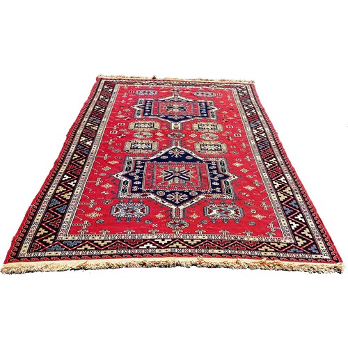 1766 - A Middle Eastern flat weave carpet with two lozenge shaped medallions on a pink ground, 275cm x 190c... 