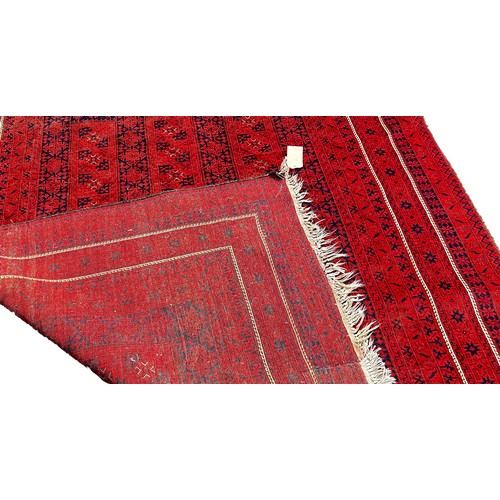 1770 - A Middle Eastern Carpet with an all over geometric pattern on a red ground, 320cm x 205cm approximat... 