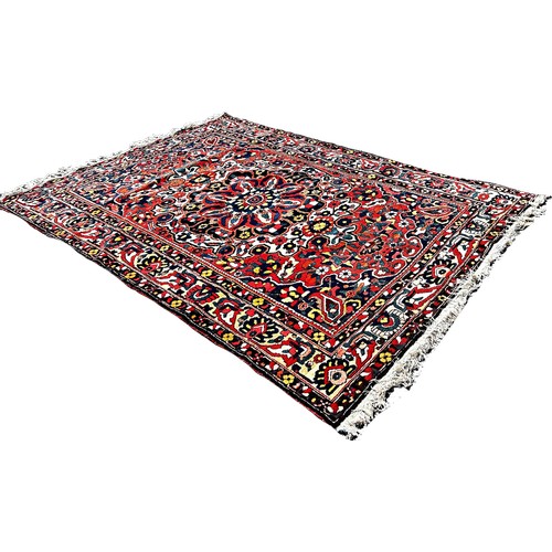 1777 - A Persian Bakthiari carpet with an all over multicoloured floral pattern 295cm x 210cm approximately