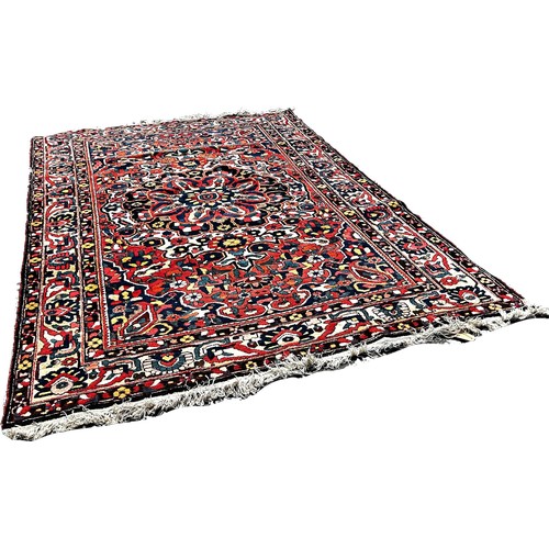 1777 - A Persian Bakthiari carpet with an all over multicoloured floral pattern 295cm x 210cm approximately