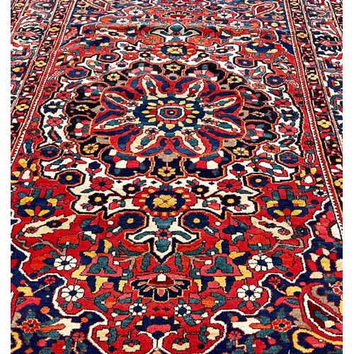 1777 - A Persian Bakthiari carpet with an all over multicoloured floral pattern 295cm x 210cm approximately