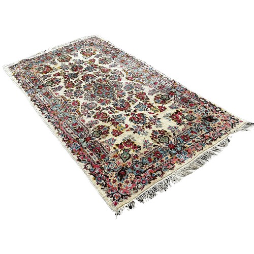 1780 - A Middle Eastern style rug with an all over floral pattern, 220cm x 120cm