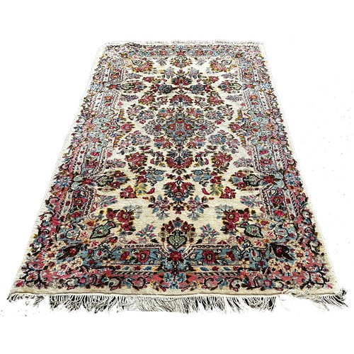 1780 - A Middle Eastern style rug with an all over floral pattern, 220cm x 120cm