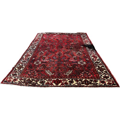 1782 - A Heriz carpet, with an all over stylised floral design on a red ground and floral border, 330cm x 2... 