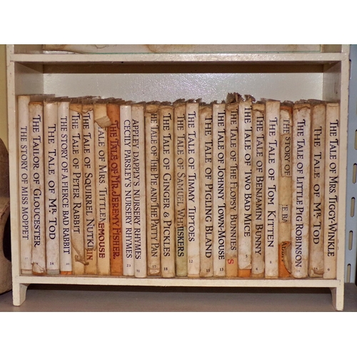 604 - A Beatrix Potter collection (24) in a small wooden bookcase, together with a wooden pull-along toy d... 