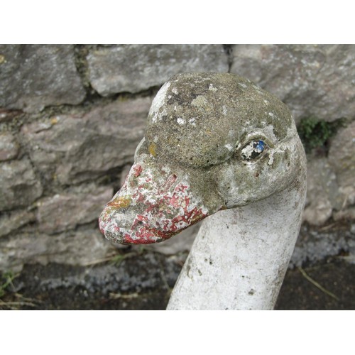 1138 - A pair of weathered painted composition stone geese garden ornaments, each 60cm high.