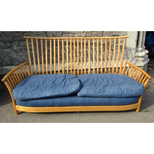 1180 - A pale Ercol wing settee with blue upholstered cushions