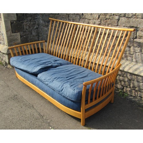 1180 - A pale Ercol wing settee with blue upholstered cushions