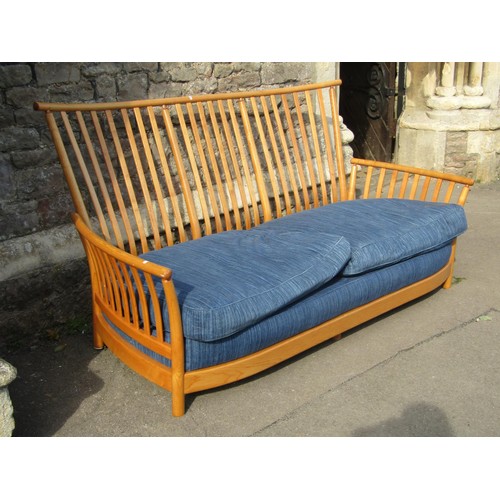 1180 - A pale Ercol wing settee with blue upholstered cushions