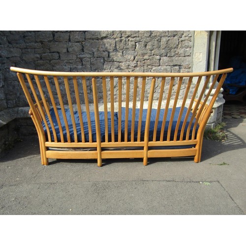 1180 - A pale Ercol wing settee with blue upholstered cushions