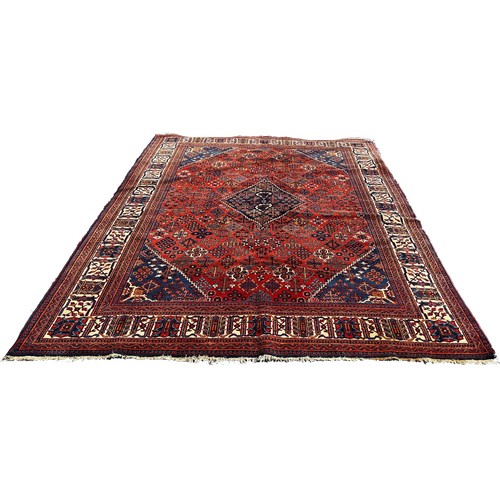 1772 - A Persian carpet with central blue diamond medallion with an all over floral design on a red and blu... 