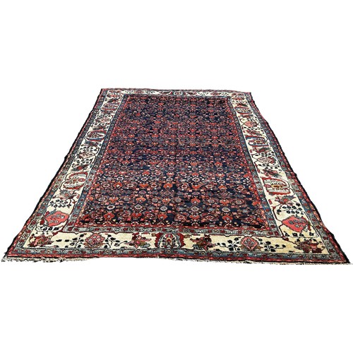 1778 - An antique Persian carpet, with an all over floral pattern on a predominantly blue ground and floral... 