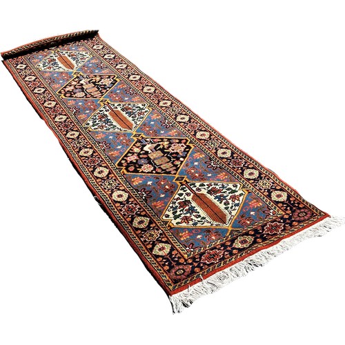 1785 - A Persian runner with alternating diamond medallions and floral borders, 290cm x 85cm approximately