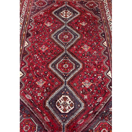 1758 - An antique Qashqai carpet with four linked diamond medallions on a predominantly red ground, 280cm x... 