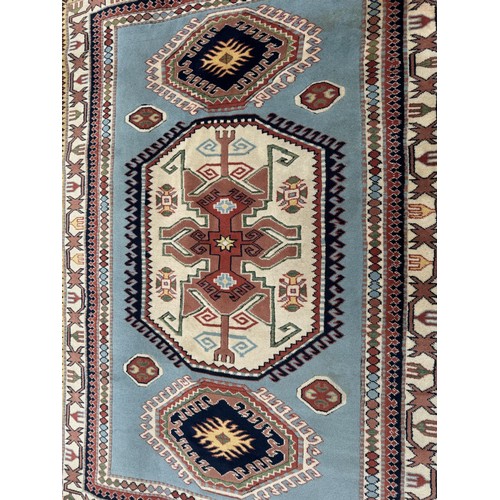 1767 - A Kazak rug in sky blue, indigo, scarlet and natural wool tones, 255 x 180 cm