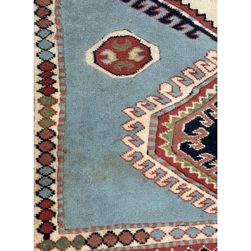 1767 - A Kazak rug in sky blue, indigo, scarlet and natural wool tones, 255 x 180 cm