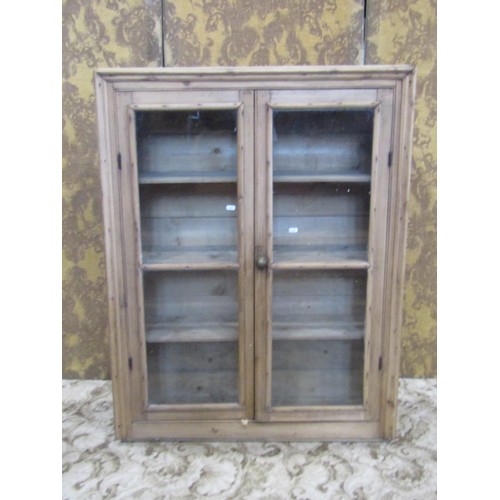 1189 - A 19th century stripped pine wall cupboard enclosed by a pair of glazed panelled doors