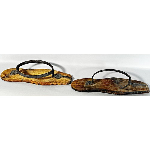 500 - A pair of 18th century iron and wood mud boots, lacking leather straps, (one as found) 25cm long.