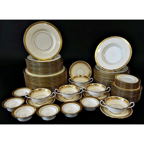 1 - A large quantity of Minton porcelain dinnerware in cream with gilt edged borders comprising 12 dinne... 