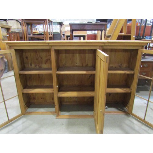 1246 - A 19th century stripped and waxed pine breakfront cabinet, the central door flanked by two glazed pa... 