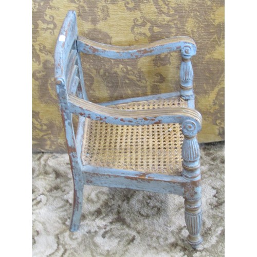 1261 - A miniature painted and scraped teak bergere caned child’s elbow chair, together with a bamboo candl... 