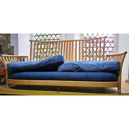 1180 - A pale Ercol wing settee with blue upholstered cushions